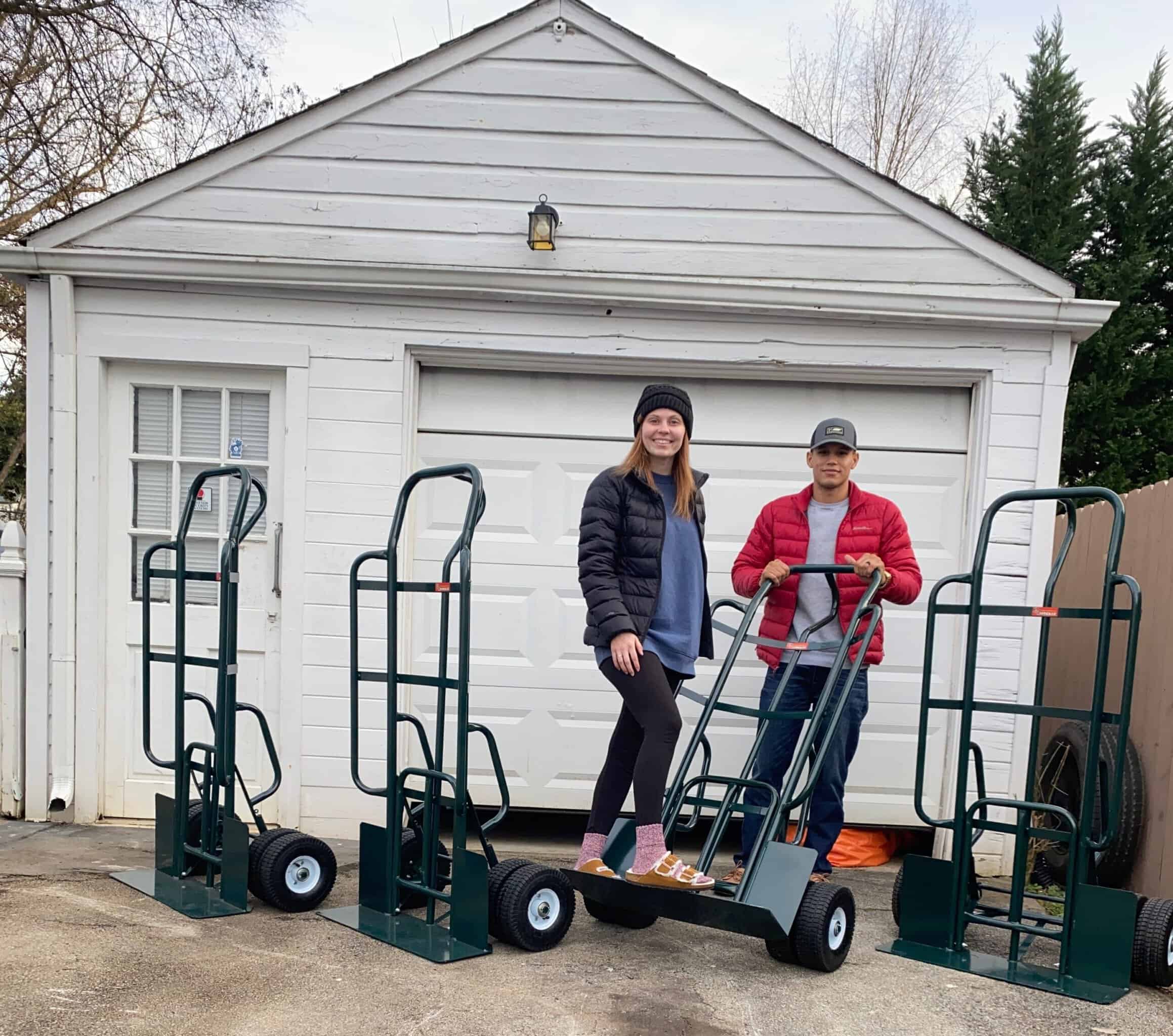 The Party Bounce House Rentals of Knoxville crew with delivery hand trucks outside their East Tennessee shop